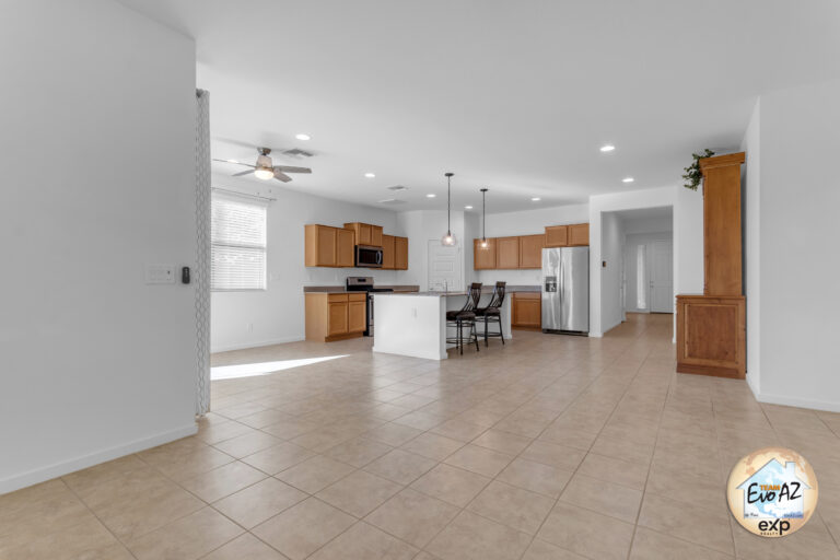 Spacious living room in a Maricopa AZ single-level home with large garage, featuring tile flooring and natural light