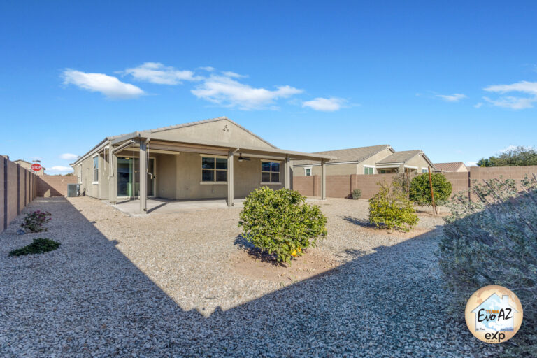 Backyard and side view of a Maricopa AZ single-level home with large garage and low-maintenance landscaping