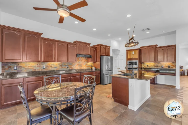 Kitchen with granite countertops and island inside a Sierra Montana home in Surprise AZ