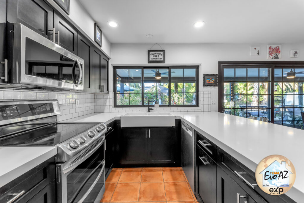 Updated kitchen with quartz countertops, dark cabinetry, and stainless steel appliances