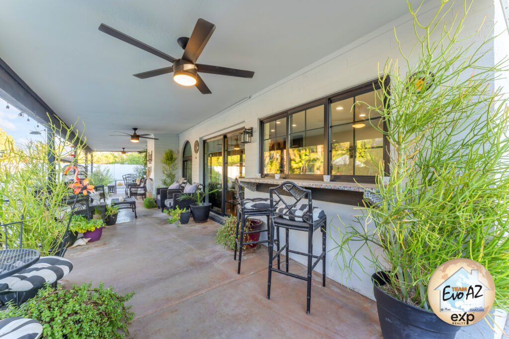 Covered patio with dining table and ceiling fan in the backyard