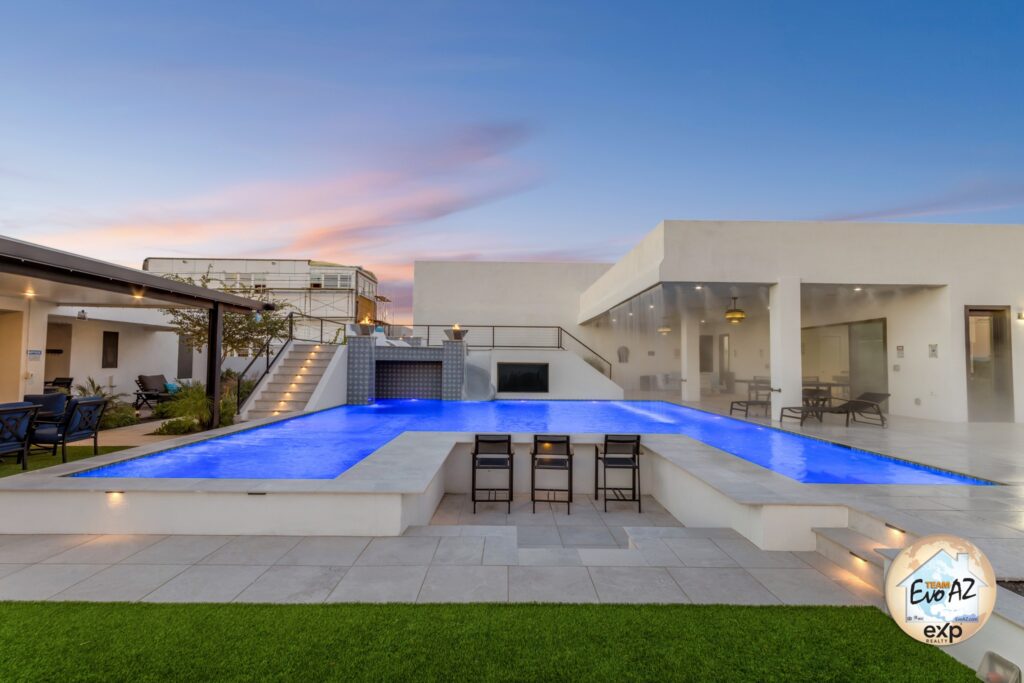 Resort-style backyard pool with waterfalls and modern design at a luxury custom home in Surprise AZ